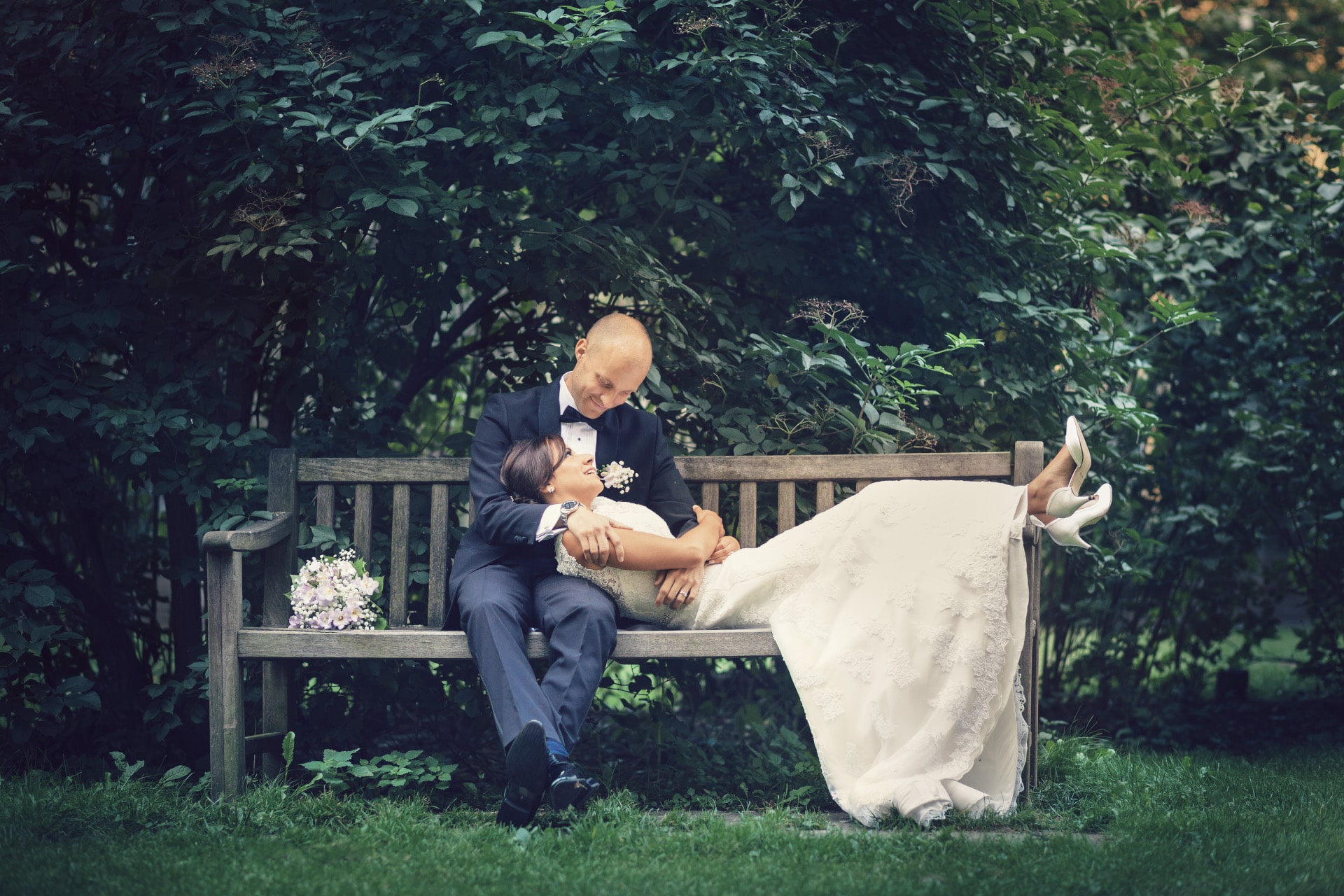 Bröllopspar på bänk i parken Bröllopspar på bänk i parken