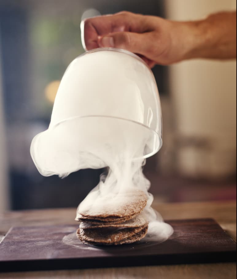 Glaskupa med konferensmat som ryker